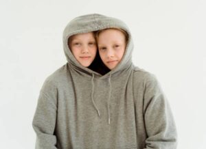 Dos niños gemenos dentro de una misma sudadera