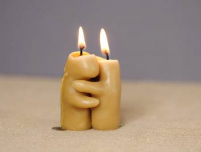 Energía sexual y amor representada por la llama de dos velas encendidas que se funden en un abrazo